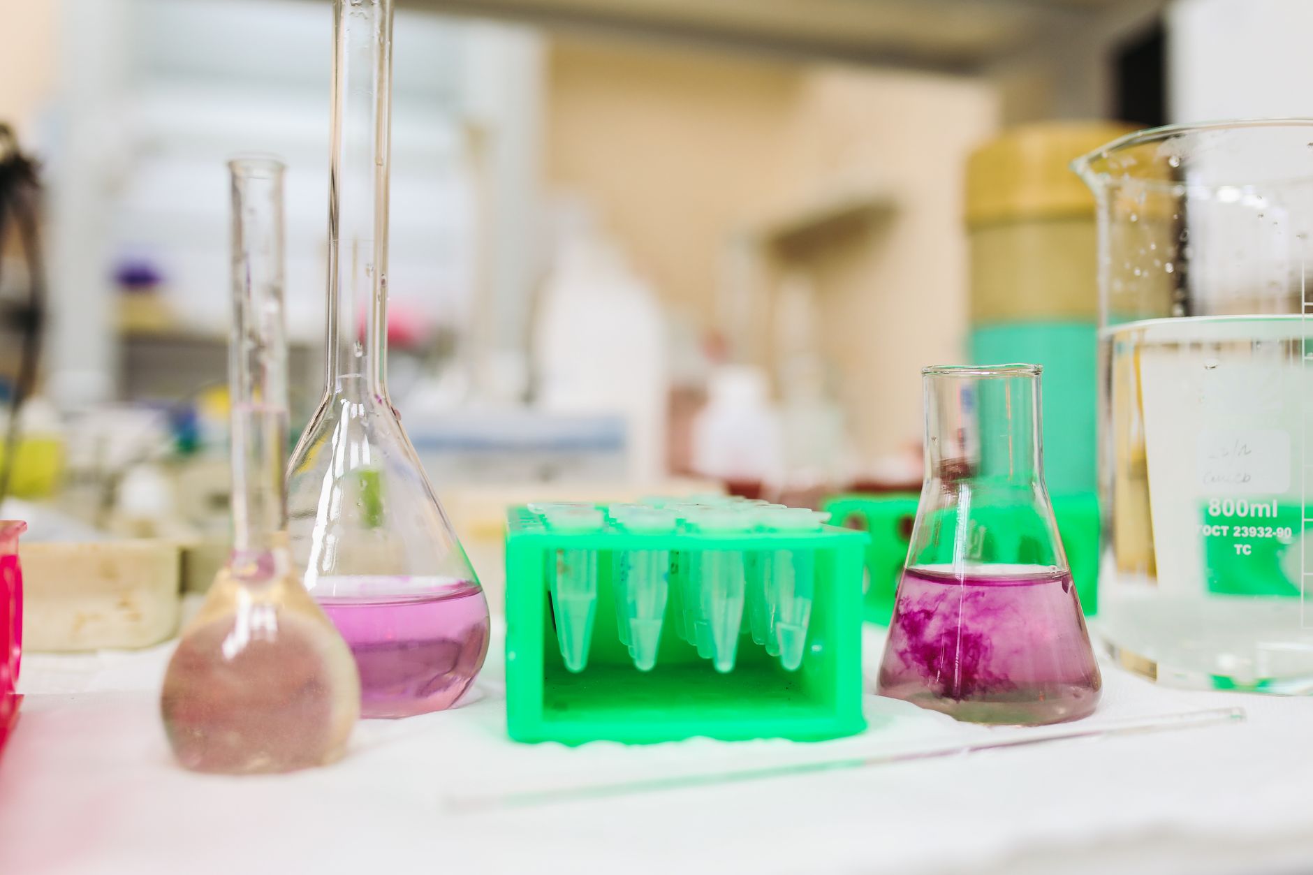 Laboratory equipment with colorful liquids in beakers and test tubes.